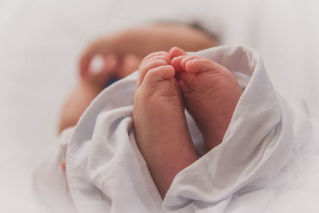 Baby lies on table awaiting vaccine