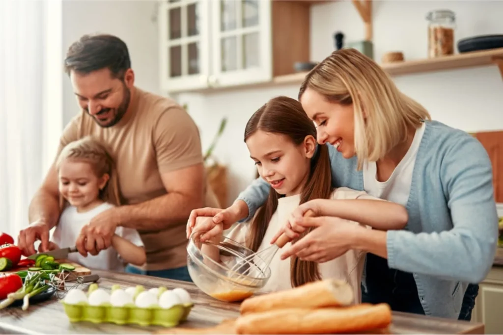 Parents and two children together in the kitchen making a meal