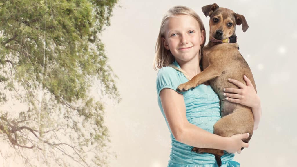Smiling girl holding a dog