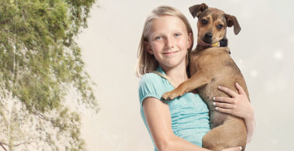 Smiling girl holding a dog