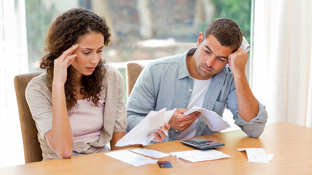 Married couple reviewing financial paperwork to manage their debt