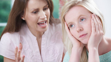 Upset mom talking at her teen daughter who doesn’t care and is turned away and staring off into space