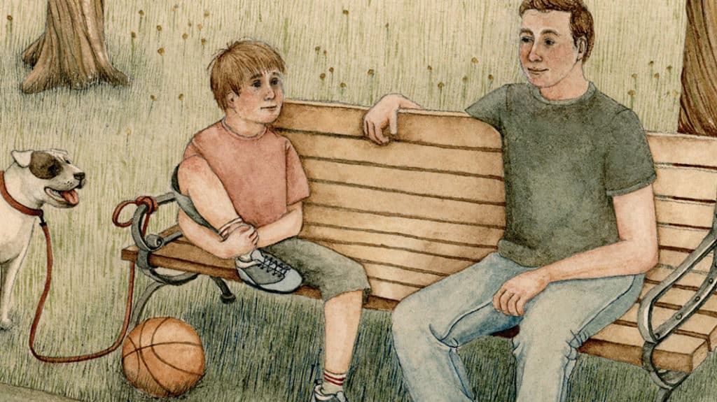 Father sitting next to his son on a park bench