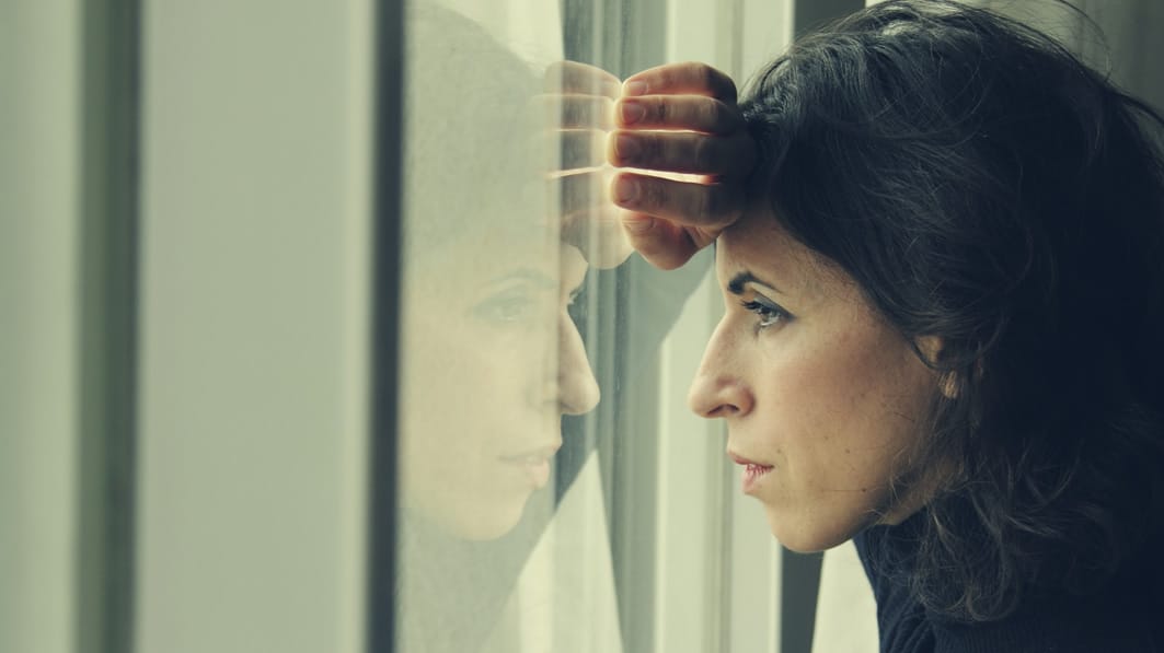 Sad woman looking out a window