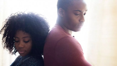 A couple standing back-to-back, both with solemn expressions, illustrating the emotional journey of how to forgive your spouse in challenging moments.