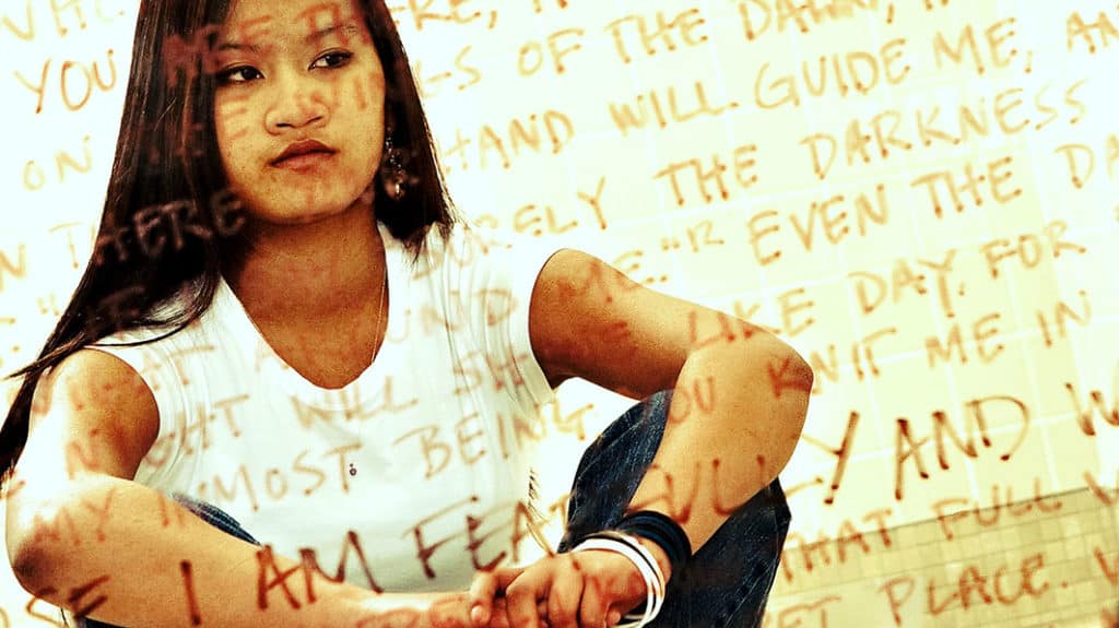 Stylized image of serious-looking teen girl with hand-written Bible verses overlaid all over the image
