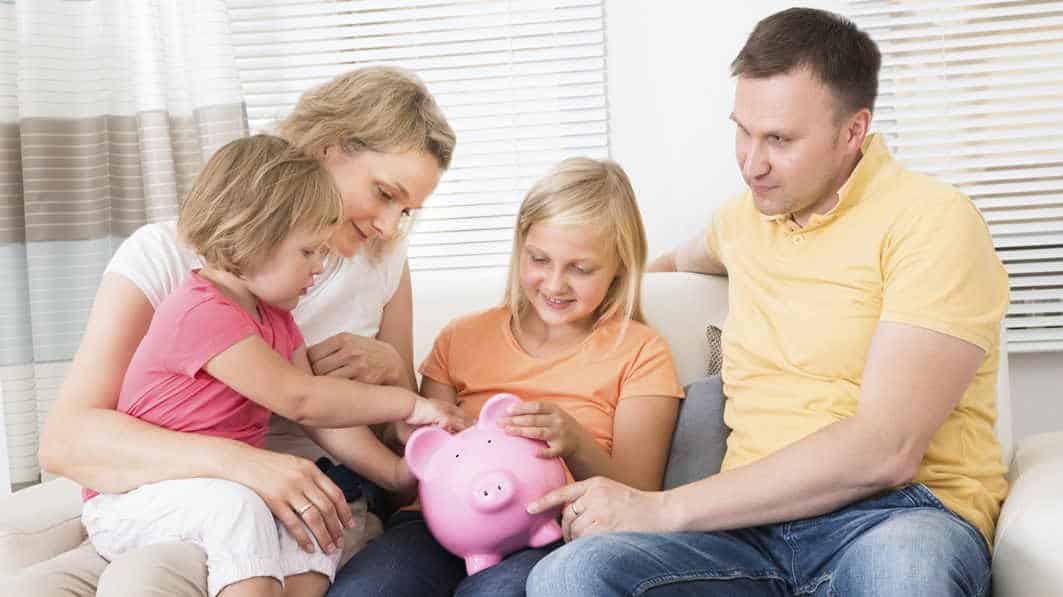 Family putting money in a piggy bank