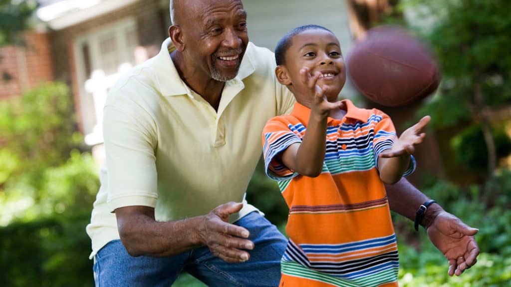 grandfather playing football with his grandson