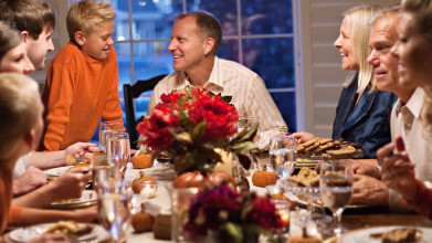 Joyful family gathered around the table having Thanksgiving dinner