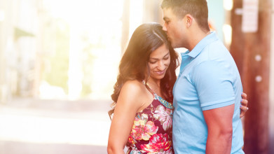 Husband kissing the top of his wife's head as they embrace