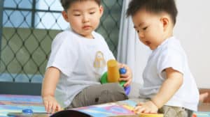 Two little boys playing together on the floor