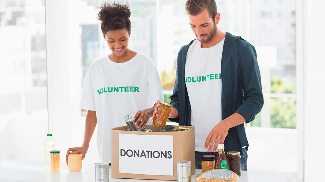 Two volunteers loading a box of donations