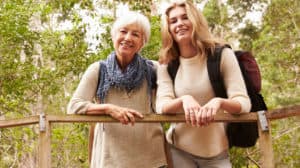 Grandmother and teenage granddaughter on a bridge in a forest