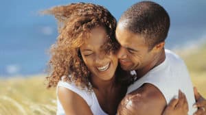 Close-up of African-American couple laughing and hugging outside