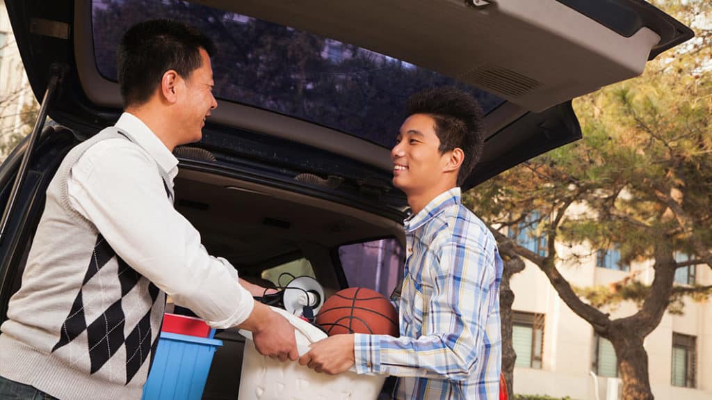 Adult child unloading car to move back home with parents