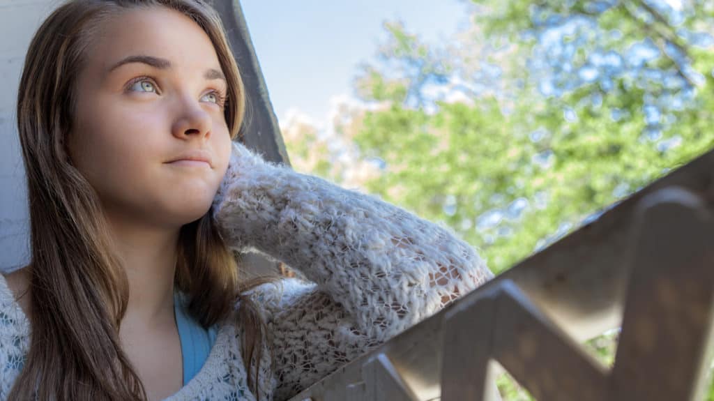 Teen girl looking up hopefully