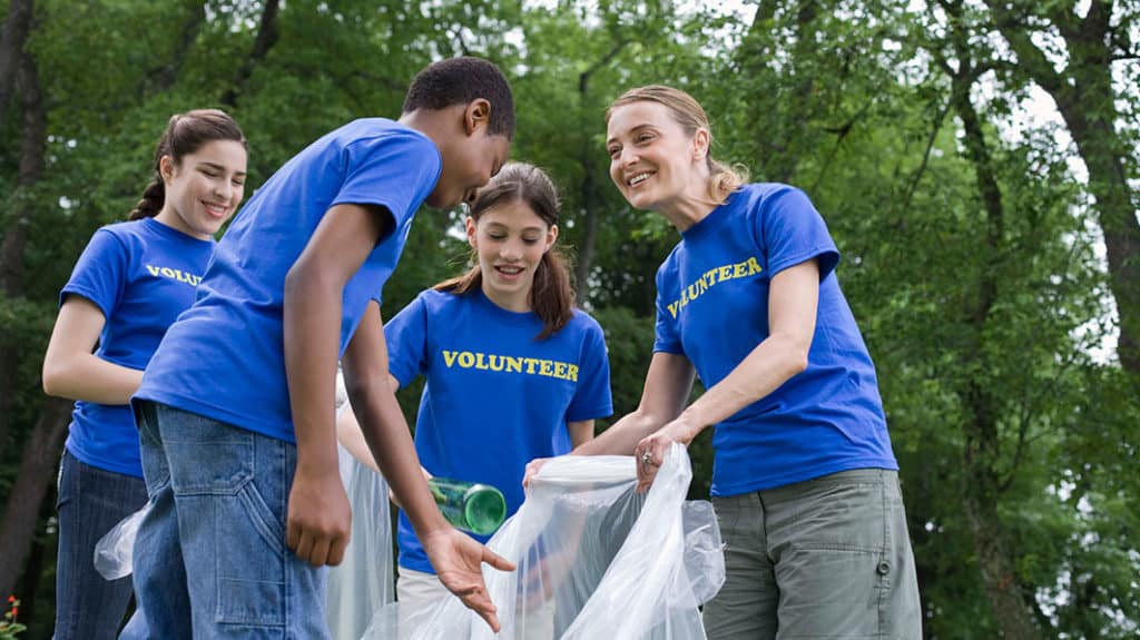 Teens volunteering together picking up trash