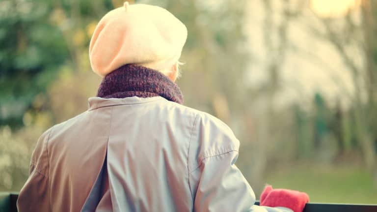 Elderly person looking into forest