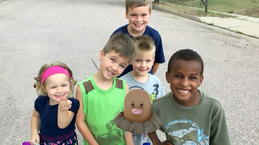 group of children play with Pokemon Go character