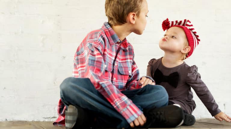 A brother and sister making faces at each other