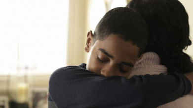 A tween boy embraces his mother