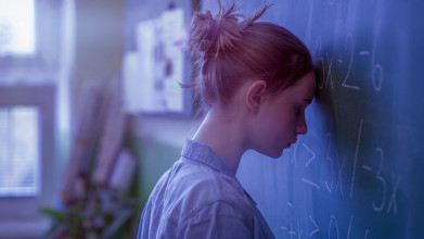 lies girls believe, young girl with her head against a chalkboard looking sad.