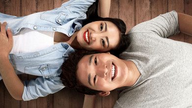 Happy couple lie close together on floor