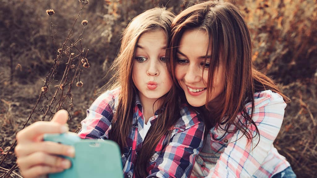 Mother and daughter taking selfies together