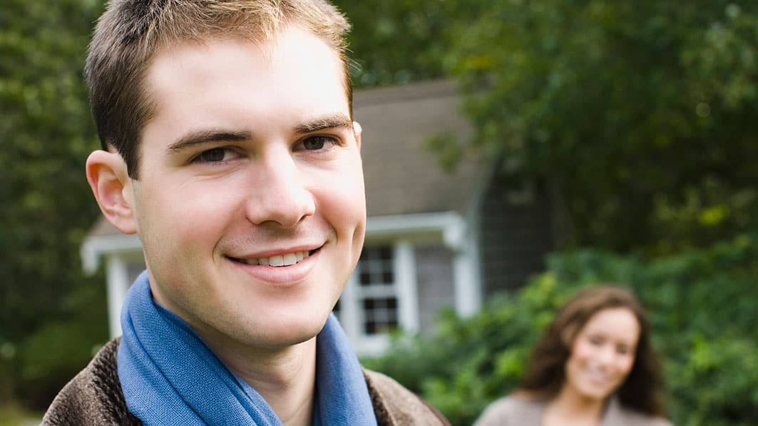 A happy husband with happy wife in background