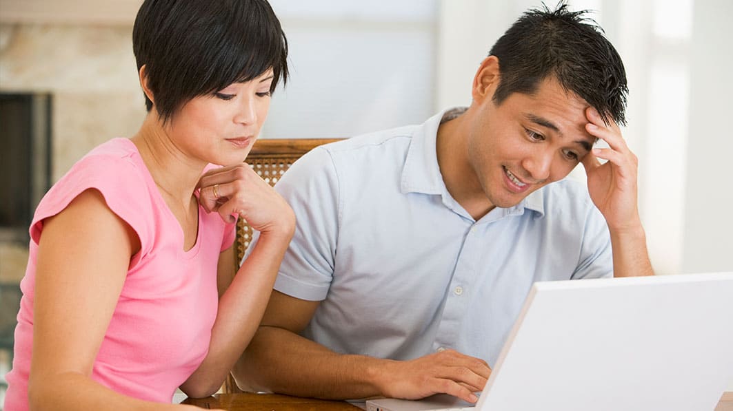 Husband and wife work through financial issues together on computer