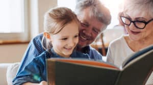 Grandparents read book with granddaughter