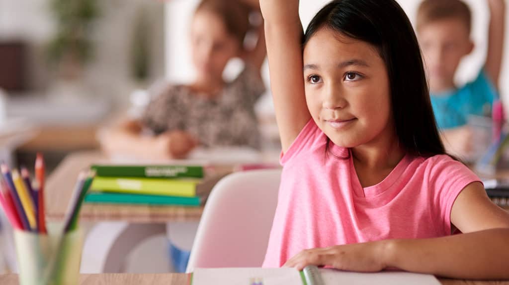 Female student raising her hand in classroom