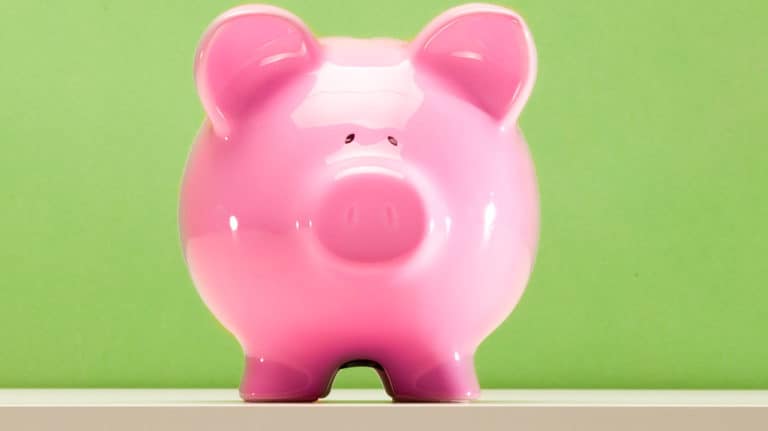 A pink piggy bank with a green background
