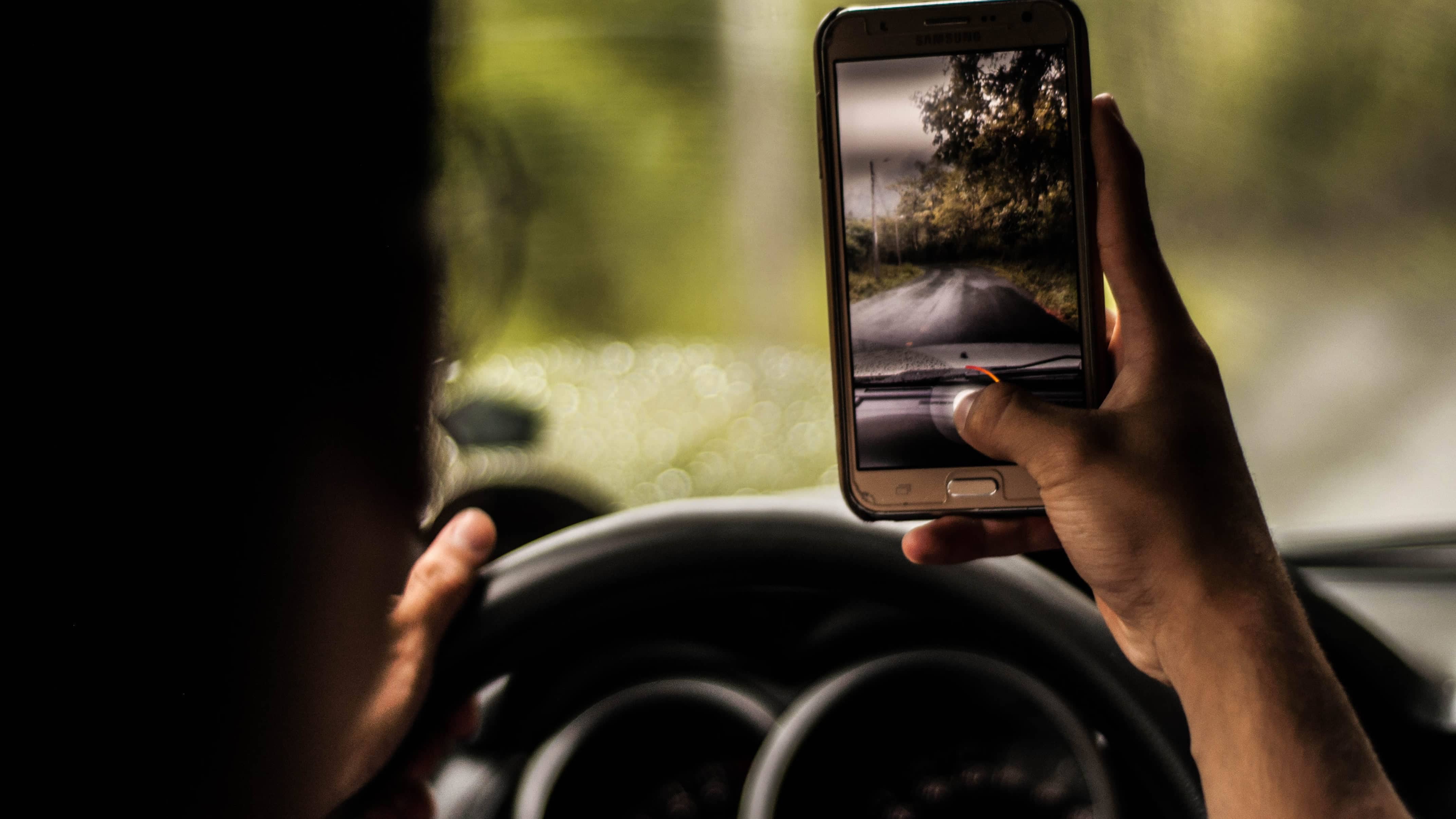 A distracted driver takes a picture of the road in front of him