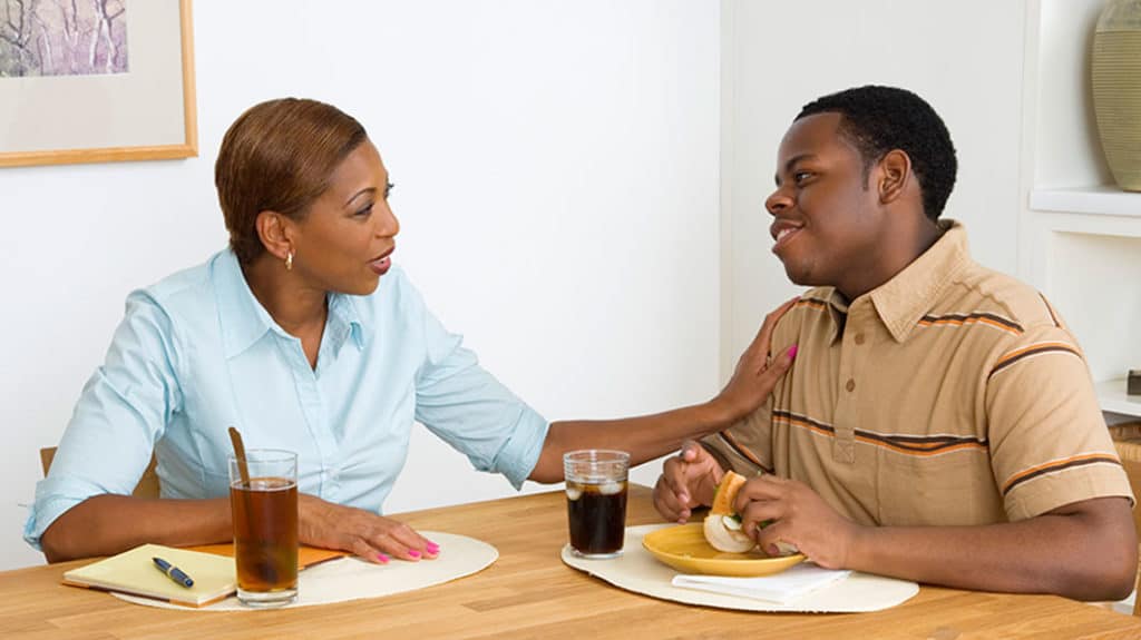 Mom has positive engagement with her teen son at kitchen table