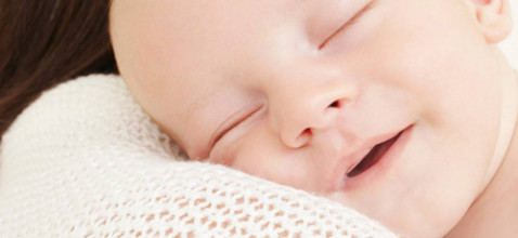Newborn sleeping and smiling