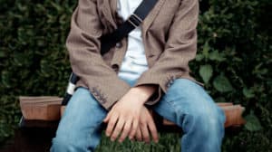 Young man sitting on a bench outside