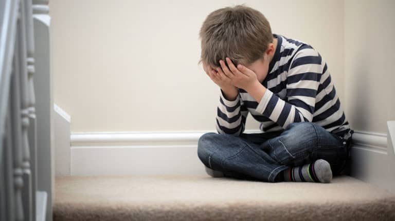 Young boy sitting on the floor crying