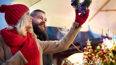 Happy young couple looking up at a Christmas decoration