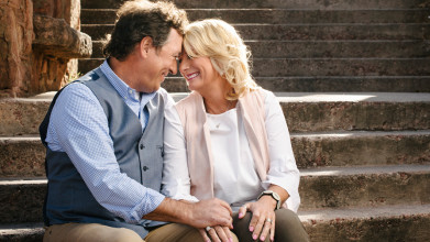 Al and Lisa Robertson smiling and being affectionate as they sit together on some steps
