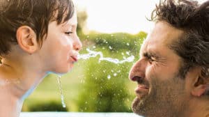 Son spitting water in Dad's face