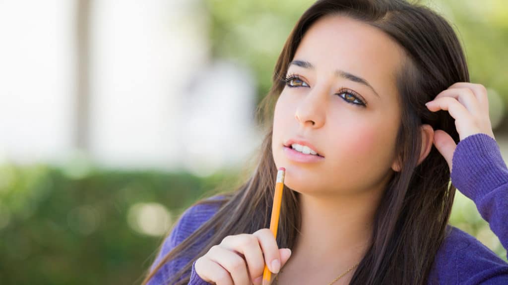 Teen girl staring off into space as if she's pondering something or deep in thought