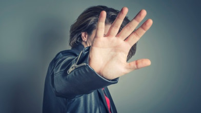 man blocking his face from camera shot