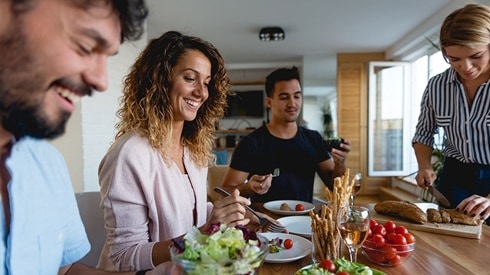 Dinner party with two young couples enjoying a meal together