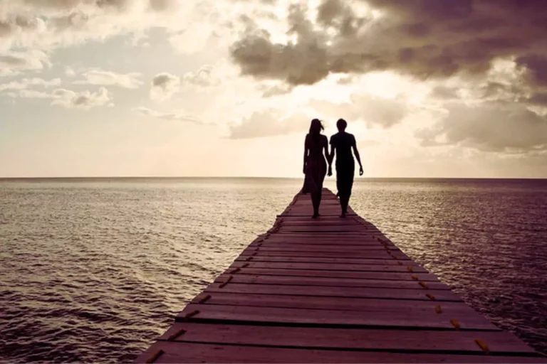 A couple walks hand in hand at sunset, reflecting the quiet strength found when knowing God can heal your marriage.