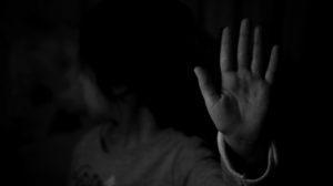 a little girl sits on the shoulders of a man while making her hands into binoculars