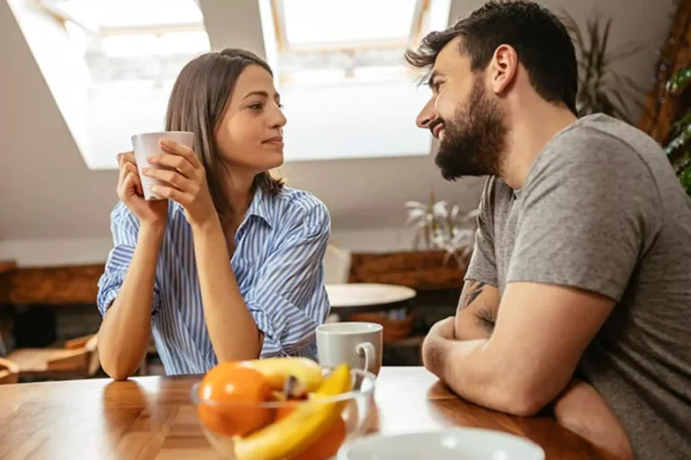 A couple sitting at a table, sharing a meaningful conversation over coffee, symbolizing the effort to learn from mistakes to improve their marriage.