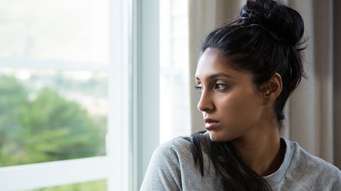 Serious looking woman staring out a window