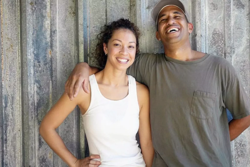 A happy couple standing together and smiling, capturing the joy that comes when you intentionally pursue your spouse.