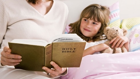 A woman reads the Bible with her child, knowing that pro-life events are a call to action.